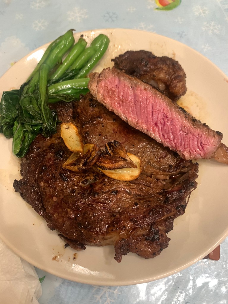 Seared steak with garlic and greens on a plate